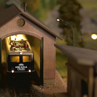 Train model in a railway shed with Arcadia Chamber logo on it.