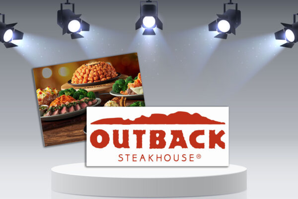 Outback Steakhouse logo with food on a table on podium with lights.