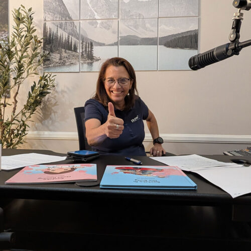 Christine Zito showing a thumbs up in her Podcast Studio.